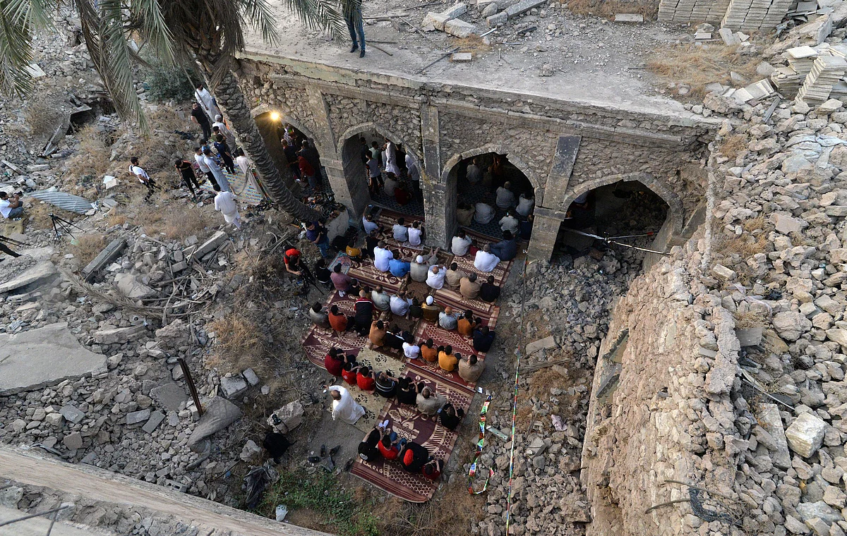 An aerial view shows Iraqi worshippers taking part in the Eid Al-Fitr prayer in the Old City of Mosul, in the courtyard of the damaged Umayad mosque, early on May 13, 2021, to mark the end of the Muslim holy month of Ramadan.