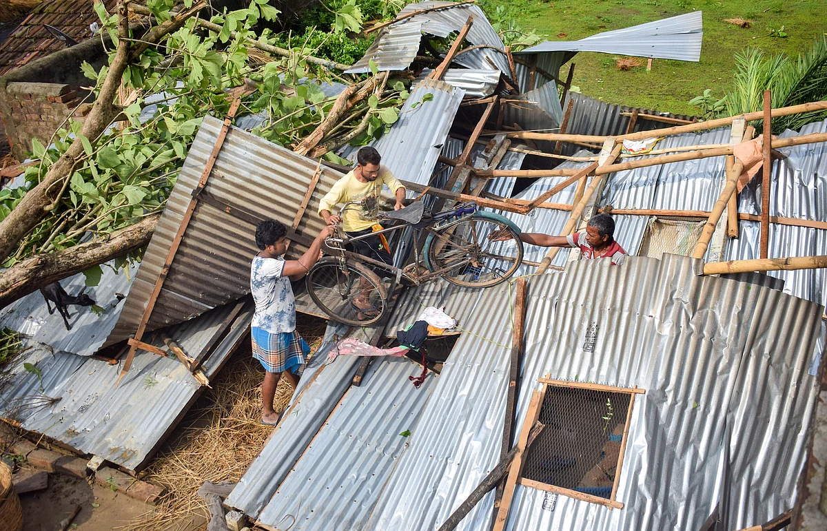A view of an uprooted tree and damaged house after cyclone Yaas, at Santipur in Nadia district, Thursday, May 27, 2021