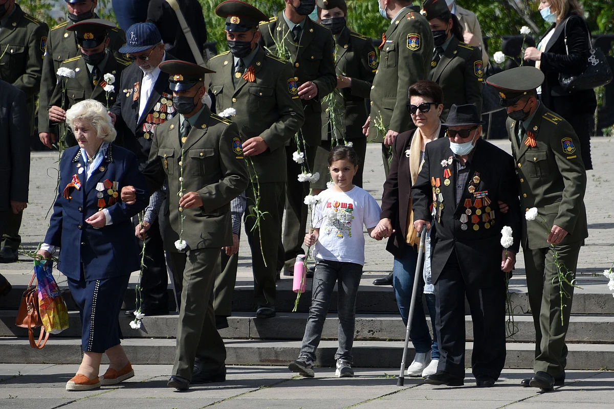 Veterans walk to lay flowers at the Mother Armenia monument in the Victory Park during the Victory Day celebrations in Yerevan on May 9, 2021.