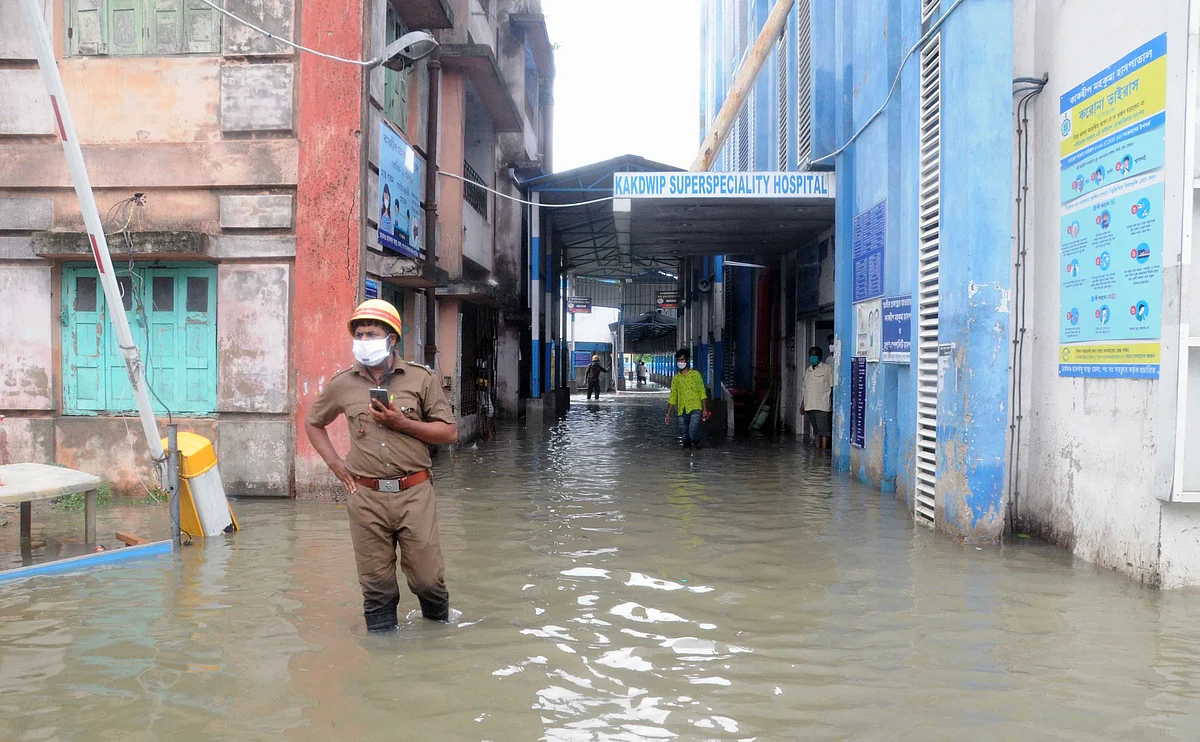 A security personnel seen standing on a water logged road outside Kakdwip Hospital after the landfall of cyclone Yaas, at Kakdwip in South 24 Paragnas, Wednesday, May 26, 2021.