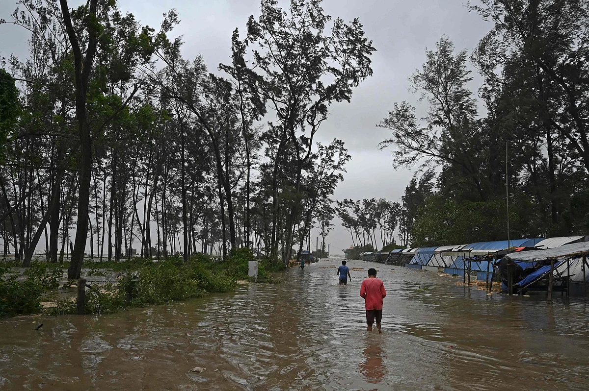 Villagers wade through the water at a flooded road to reach a shelter as Cyclone Yaas barrels towards Indias eastern coast in the Bay of Bengal, in Digha some 190 Km from Kolkata on May 26, 2021.
