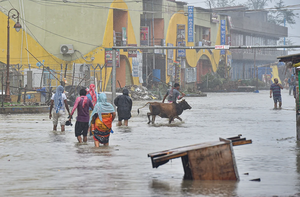 Digha: Pedestrians wade through a flooded road during landfall of cyclone Yaas at Digha in East Midnapore district, Wednesay, May 26, 2021.