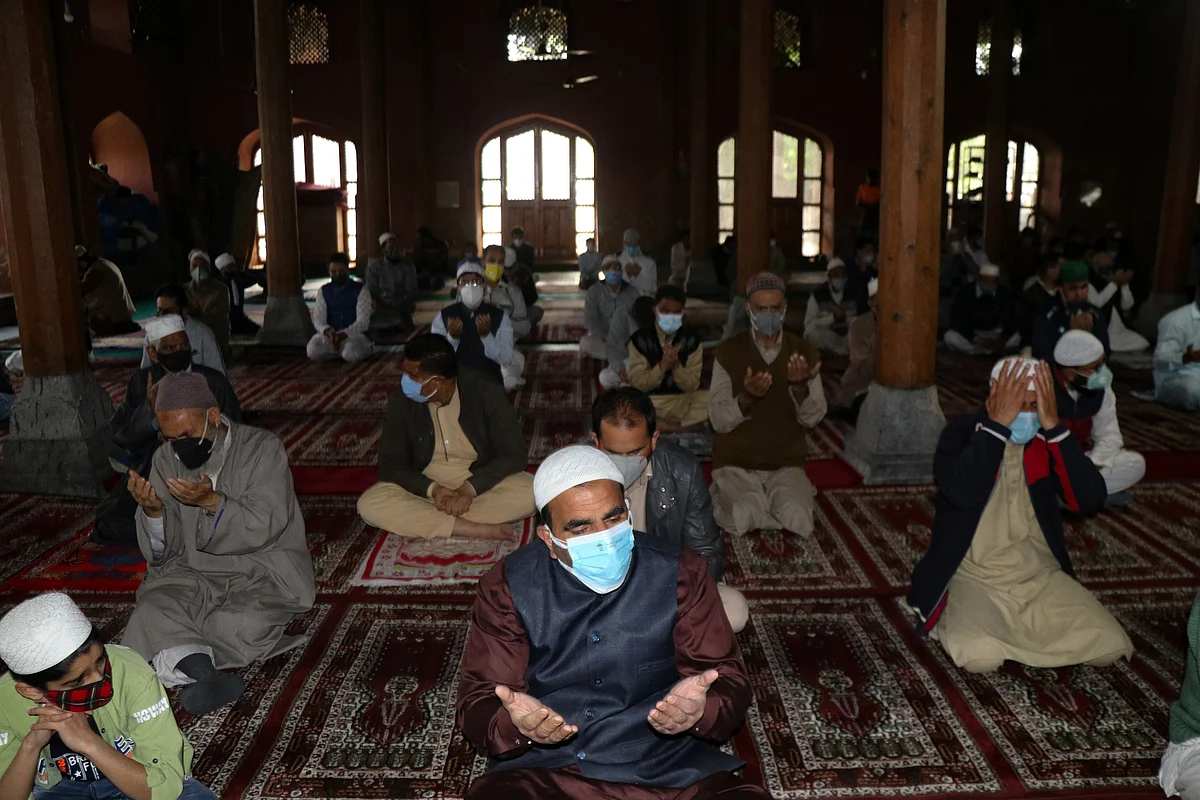 Worshippers wearing protective face masks offer Eid ul-Fitr prayers inside a local mosque to help prevent the spread of Coronavirus in Srinagar, Kashmir.