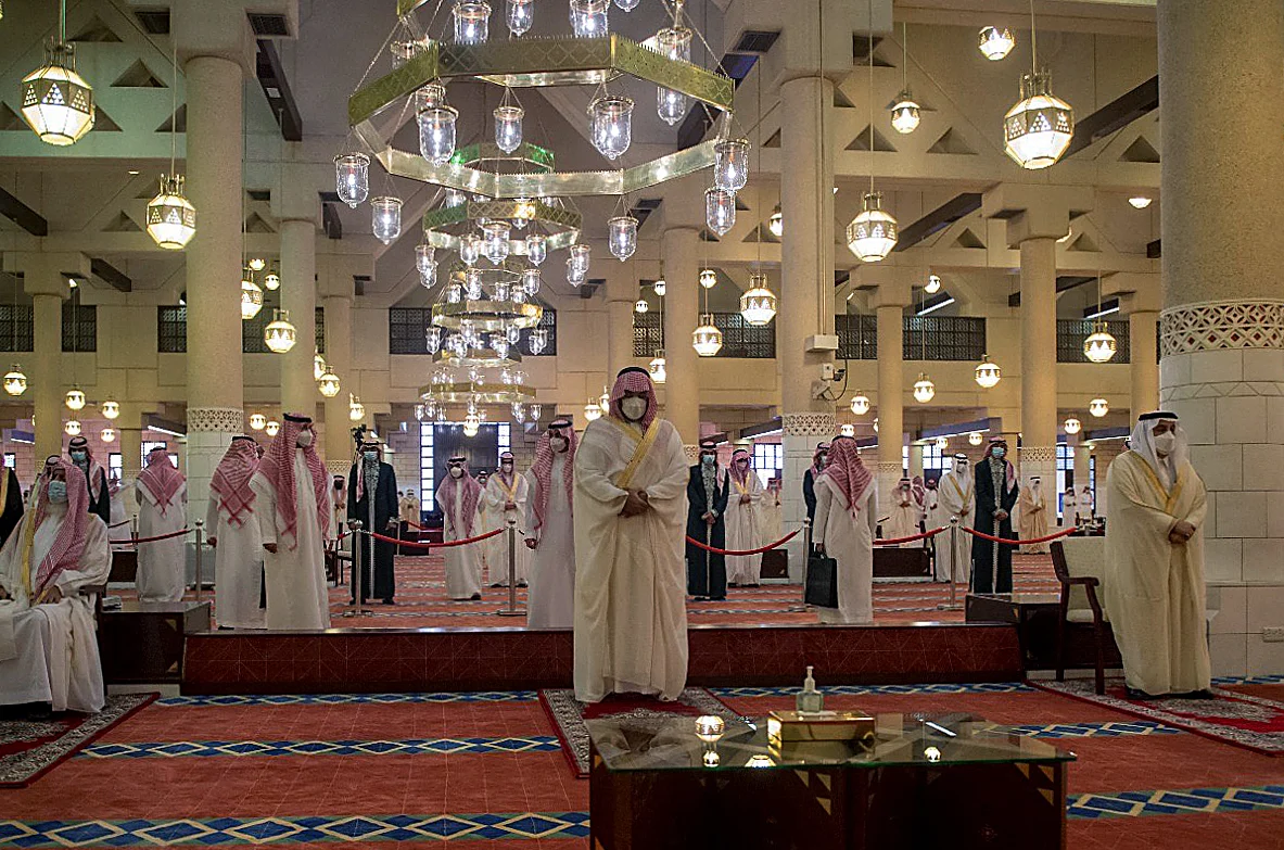 A handout picture provided by the Saudi Royal Palace on May 13, 2021, shows Saudi Crown Prince Mohammed bin Salman (C) taking part in the Eid al-Fitr prayer, marking the end of the Muslim holy month of Ramadan, at a mosque in the capital Riyadh.