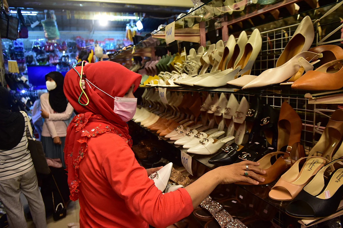 In this photo taken on May 9, 2021 a woman shops for shoes at a market amid concerns over the spread of the Coronavirus in the southern Thai province of Narathiwat, ahead of the Eid ul-Fitr festival marking the end of the Islamic holy month of Ramadan.