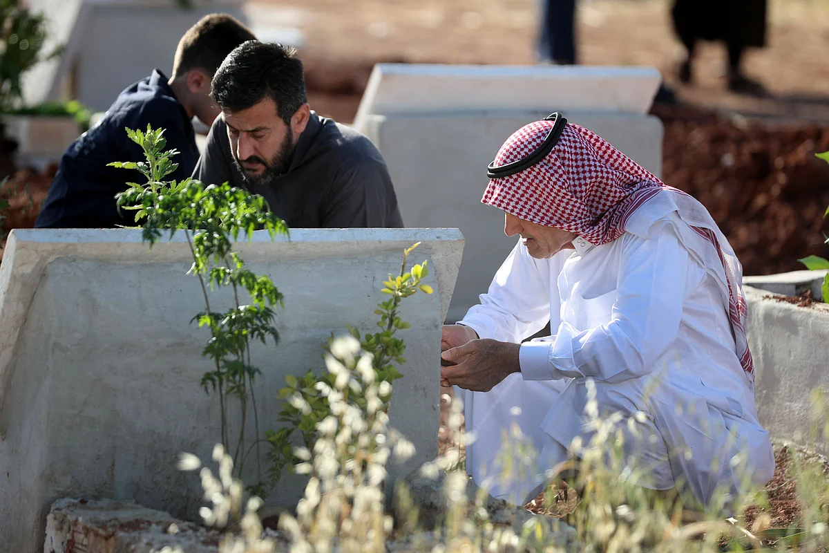 Syrian Muslims visit the graves of relatives at a cemetery of Binnish in Syrias rebel-held northwestern province of Idlib on May 13, 2021, on the first day of the Eid al-Fitr holiday, which marks the end of the holy fasting month of Ramadan.