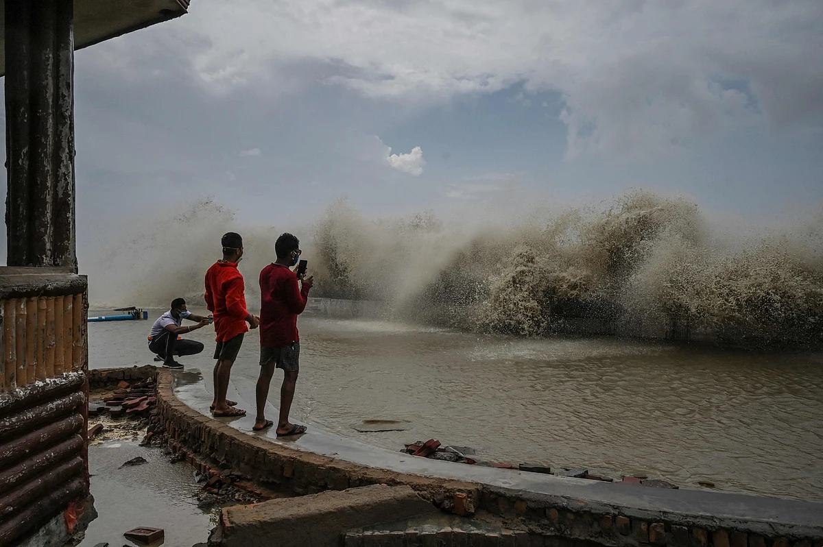Residents take pictures of waves lashing onto a shoreline after Cyclone Yaas hit Indias eastern coast in the Bay of Bengal in Digha, some 190 km from Kolkata on May 27, 2021.