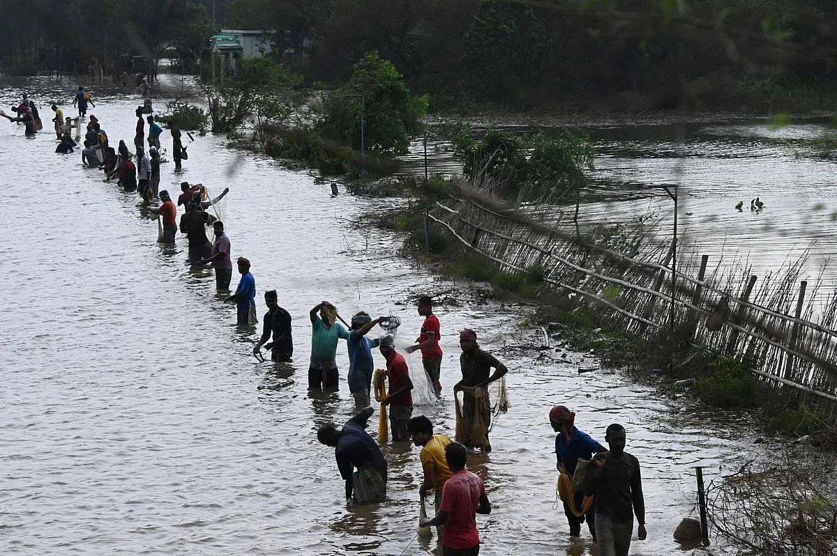 Fishermen throw fishing nets to catch fish from a overflowed field after Cyclone Yaas hit Indias eastern coast in the Bay of Bengal in Tajpur, some 170 km from Kolkata on May 27, 2021.
