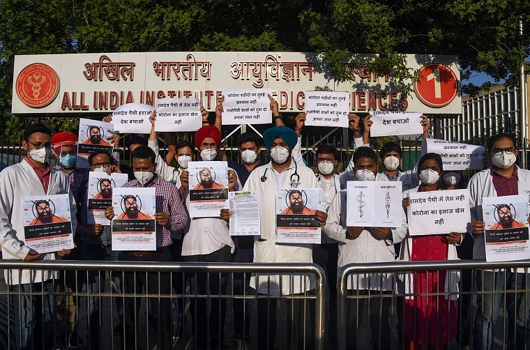 AIIMS resident doctors stage a protest against Swami Ramdev over his remarks on allopathy science, outside AIIMS hospital in New Delhi on Tuesday