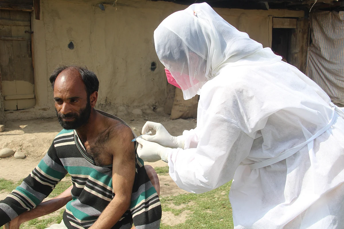 A health worker administers a COVID-19 vaccine to an elderly nomad man in a remote village of Central Kashmir's Budgam district.