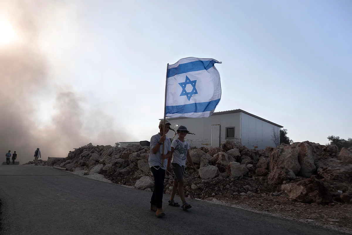 Eviatar: Israeli youths carry flags at the outpost of Eviatar near the northern West Bank town of Nablus, Monday, June 21, 2021.