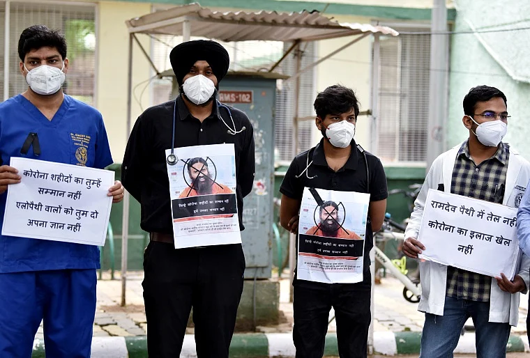 AIIMS resident doctors hold placards as they observe Black Day during a protest against Yog Guru Ramdevs remarks on Allopathy, in New Delhi