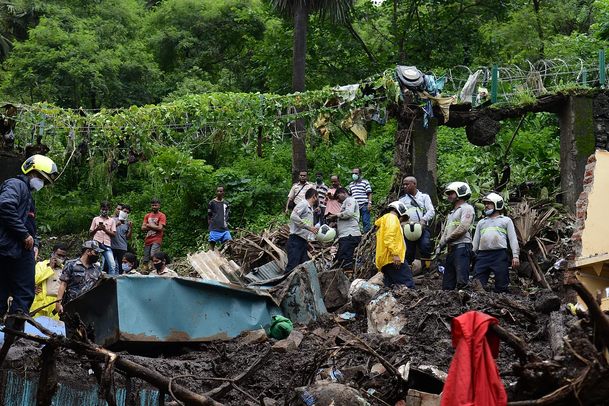 NDRF) and other rescue team personnel inspect the site of the landslide in a slum area where 18 people were killed after several homes were crushed by a collapsed wall and a landslide triggered by heavy monsoon rains in Mumbai on July 18, 2021.