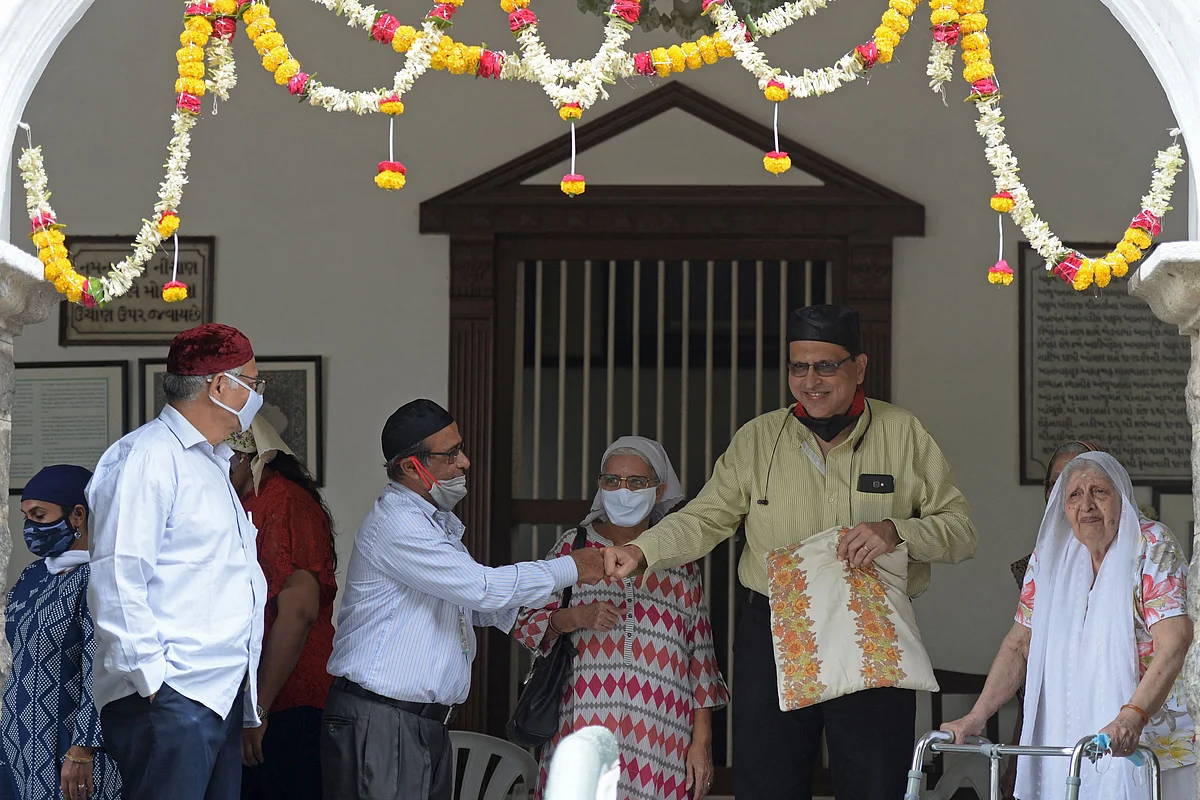 Parsi family members greet each other at the fire temple on the occasion of Parsi New Year in Hyderabad on August 16, 2021.