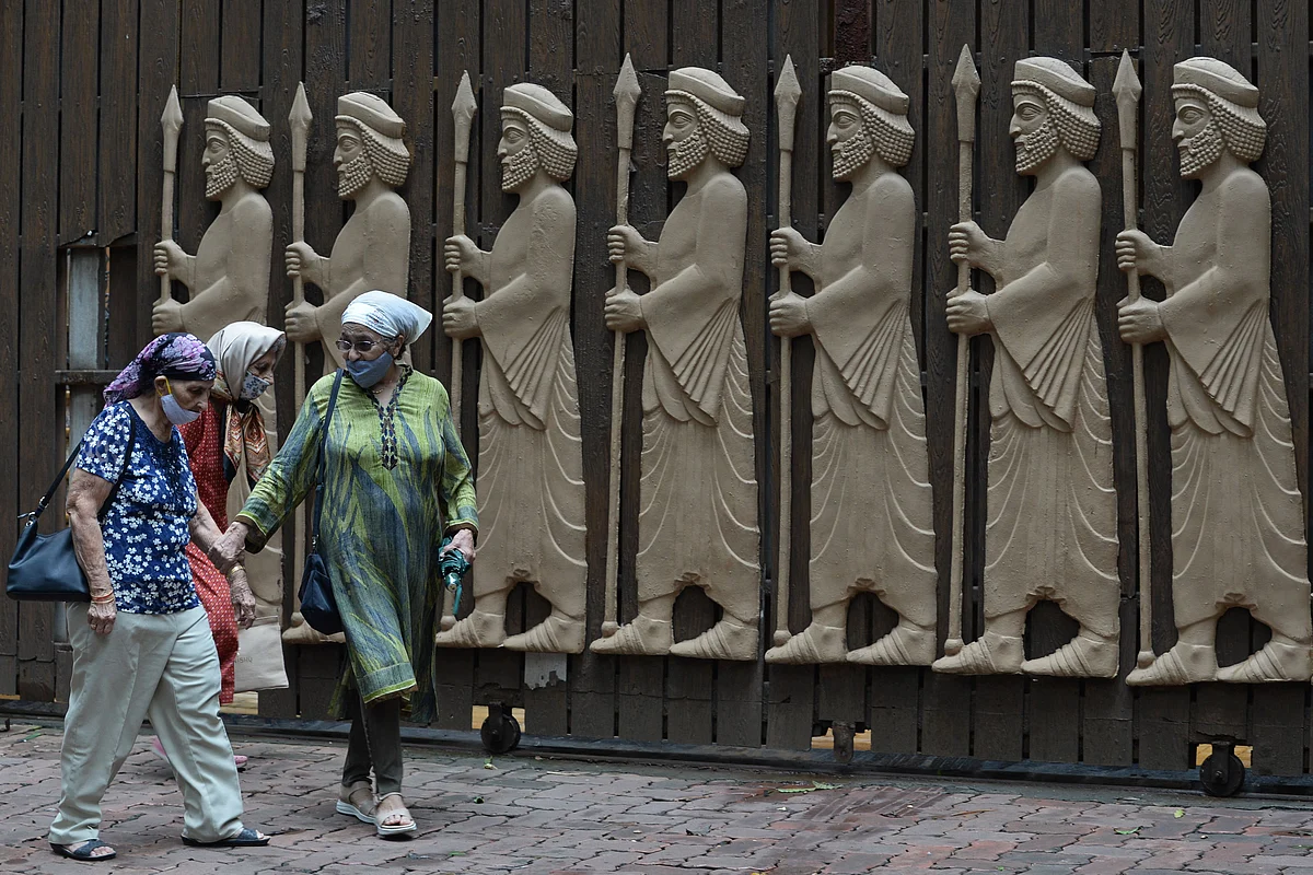Women walk past the relief figures of knights at a fire temple on the occasion of Parsi New Year in Mumbai on August 16, 2021.