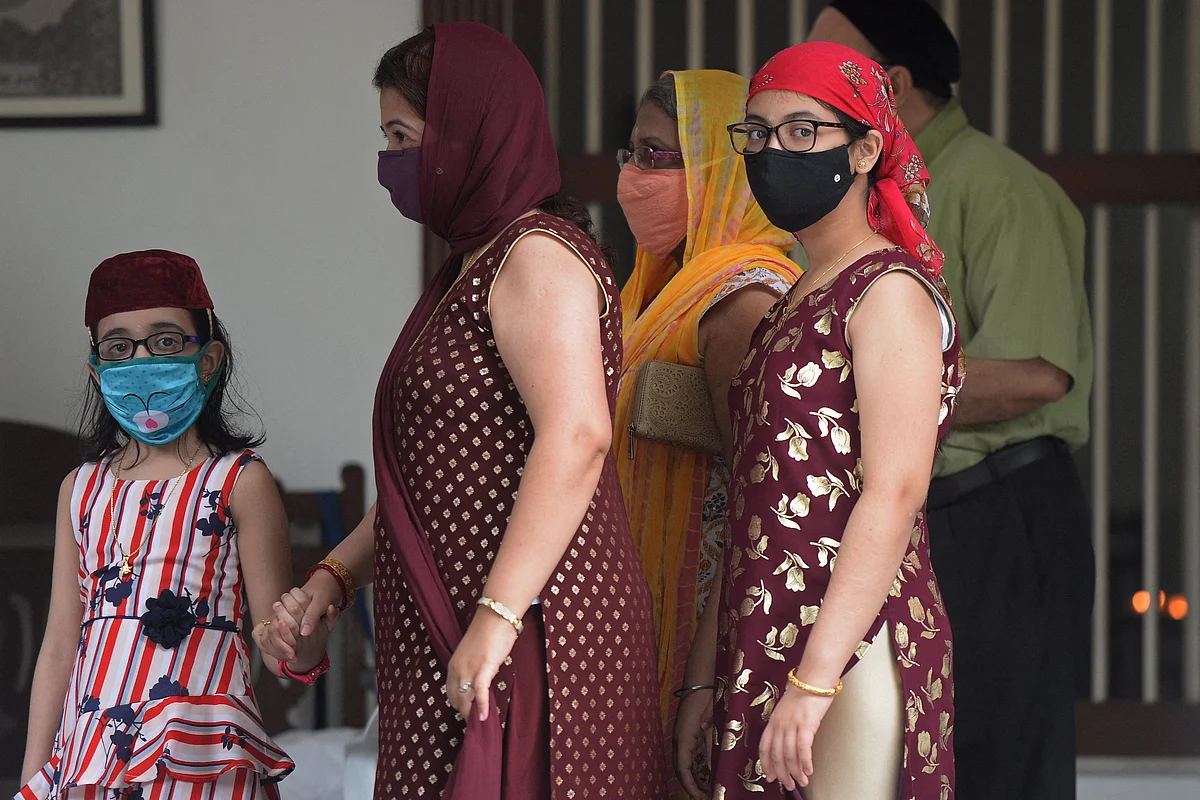 Parsi family members walk after paying respect at the fire temple on the occasion of Parsi New Year in Hyderabad on August 16, 2021.