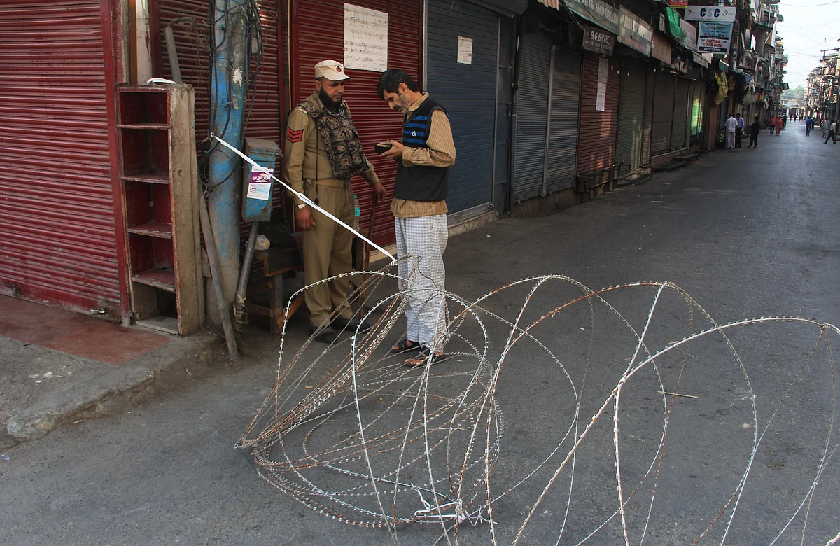 A policeman questions a man on a street during restrictions in Srinagar, Jammu & Kashmir on September 2, 2021.
