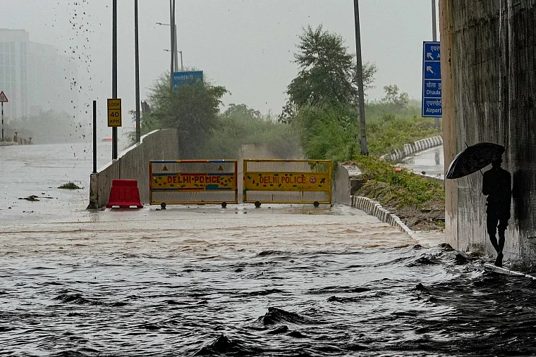 Police barricades set up at Mahipalpur-Delhi Aerocity NH 8 underpass as it closes due to heavy waterlogging triggered by rainfall, in New Delhi on Saturday.