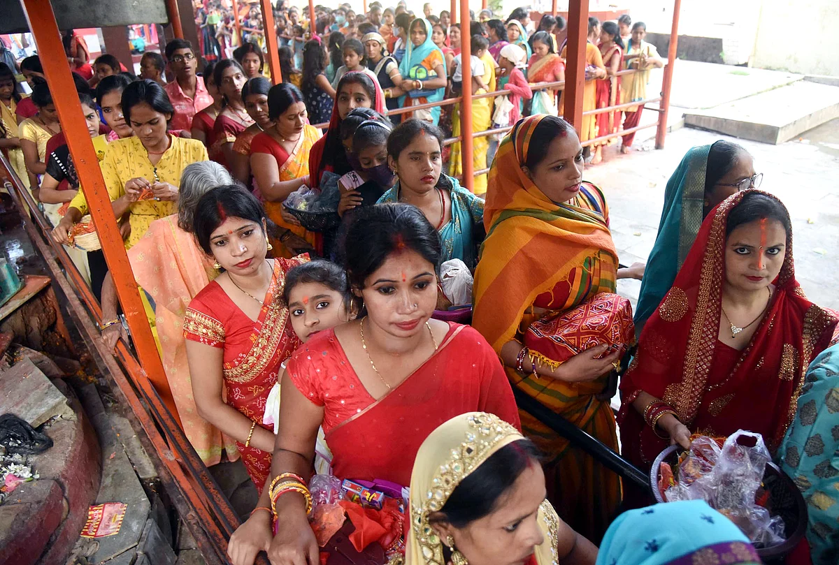 Devotees stand in queues to offer prayers outside the temple on the occasion of the Navami of Navratri festival at Agam Kuan, in Patna on Thursday.