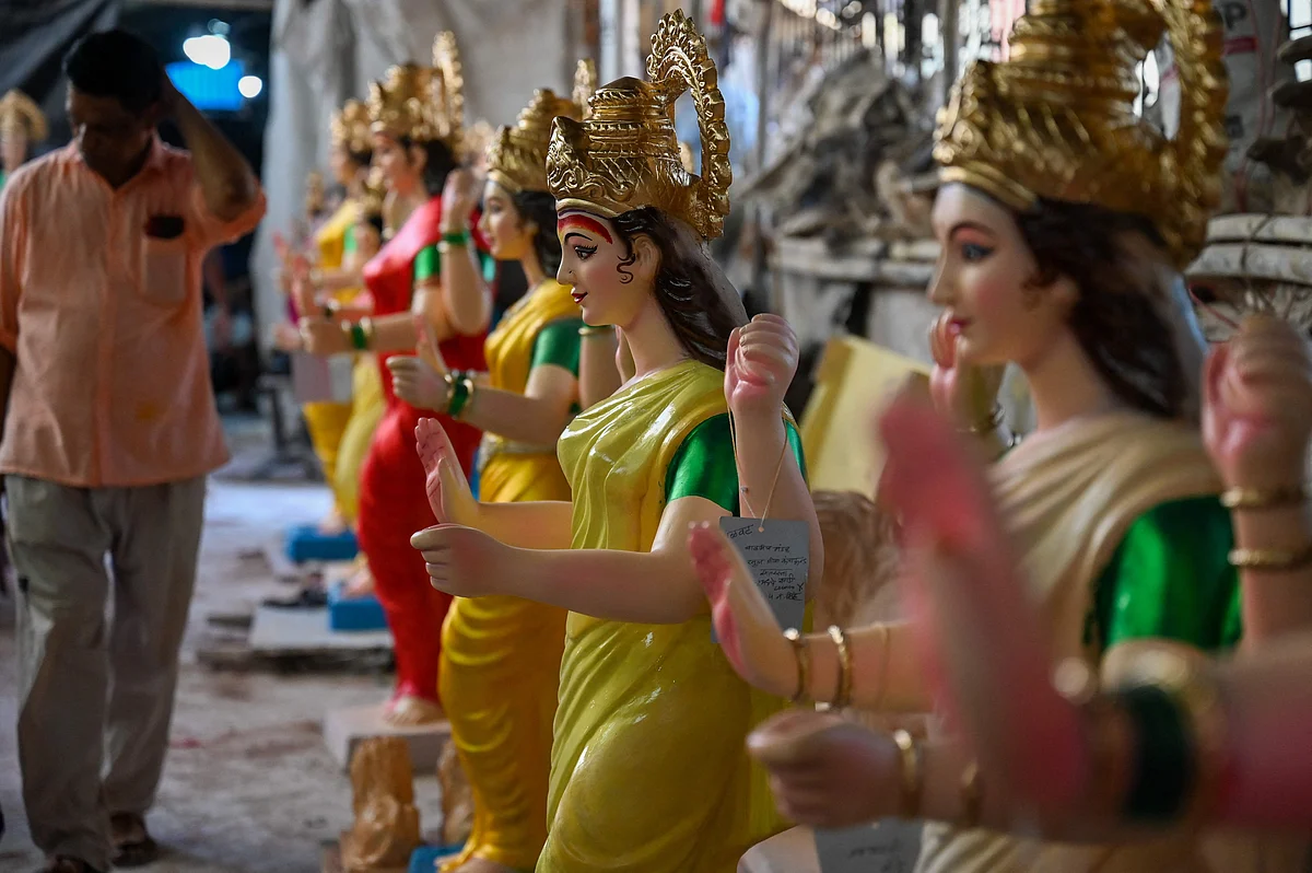 An artisan walks past idols of the Hindu goddess Durga at a workshop ahead of the upcoming Navratri festival, in Mumbai on October 5, 2021.