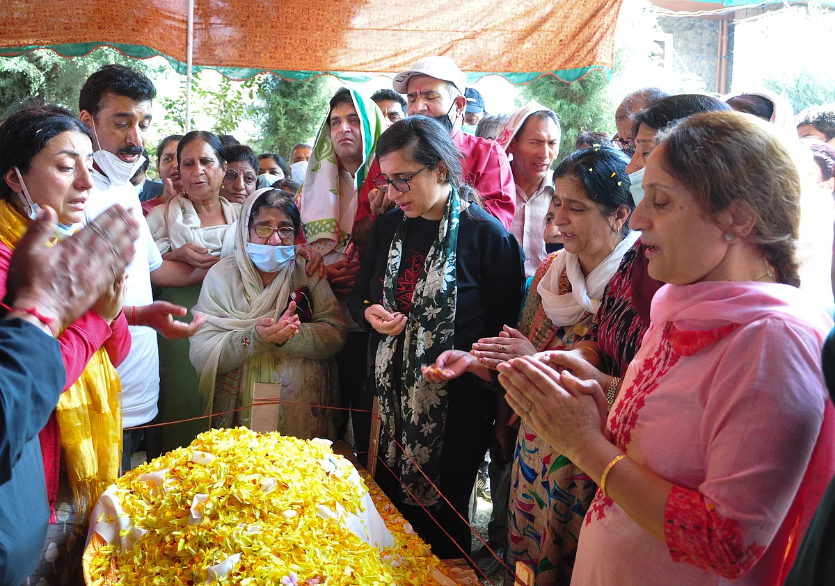 Relatives mourn around the body of prominent pharmacist Makhan Lal Bindroo during his funeral at his residence in Srinagar, Kashmir on Wednesday, October 6, 2021.
