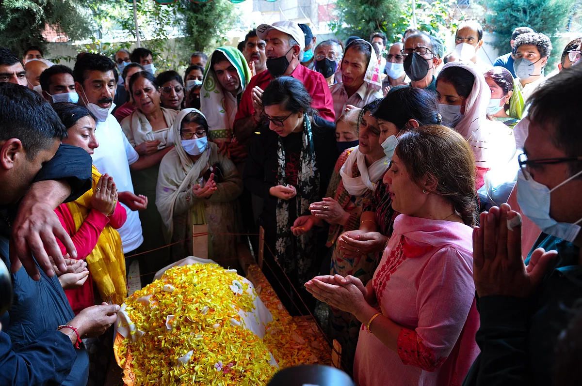 Relatives mourn around the body of prominent pharmacist Makhan Lal Bindroo during his funeral at his residence in Srinagar, Kashmir on Wednesday, October 6, 2021.