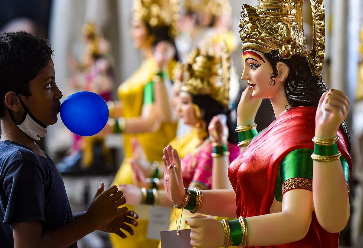 A boy looks on at a clay idol of the Hindu goddess Durga at a workshop, ahead of the Navratri festival, in Mumbai, Tuesday, Oct. 5, 2021.