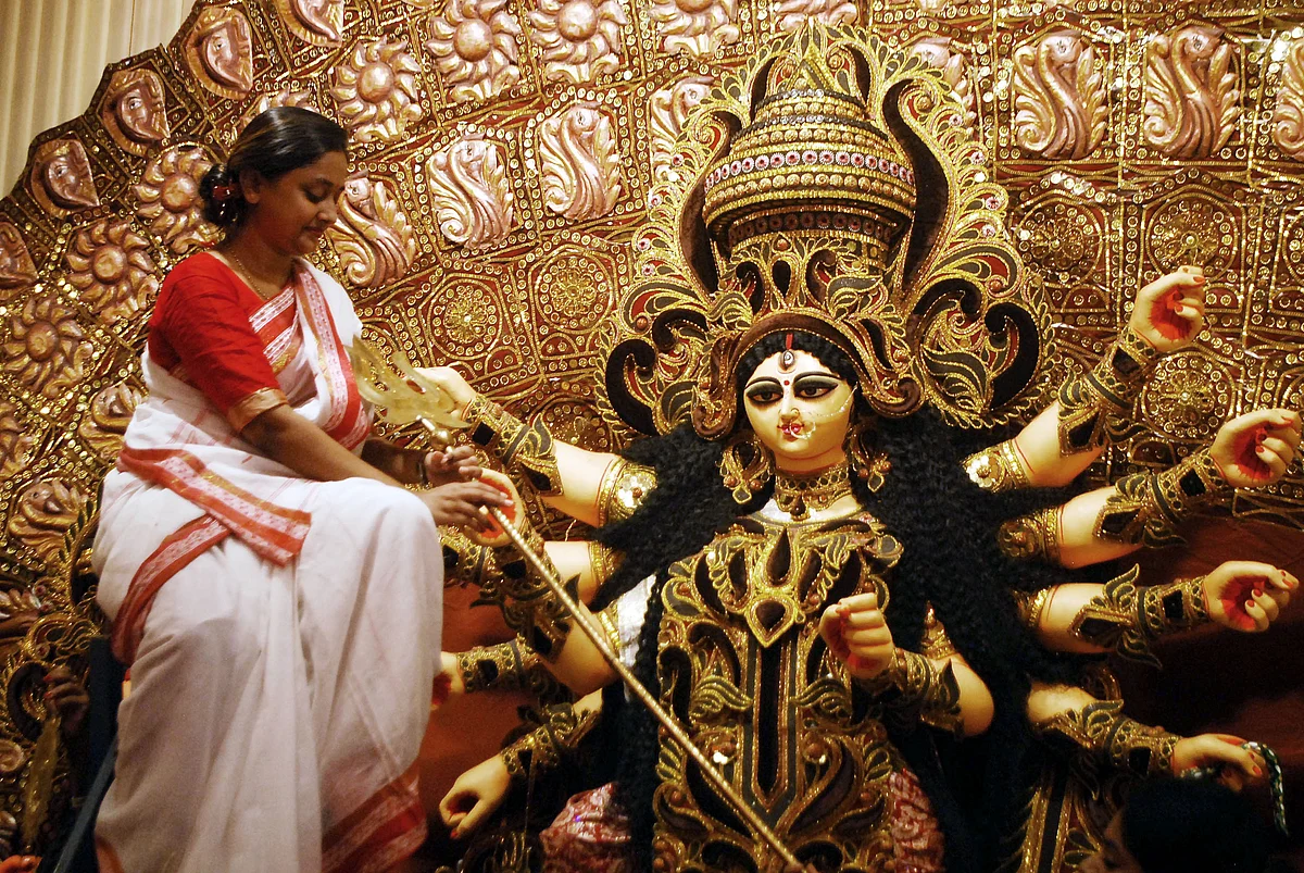 A woman decorates an idol of Goddess Durga ahead of the Durga Puja festival, in Kolkata on Tuesday.