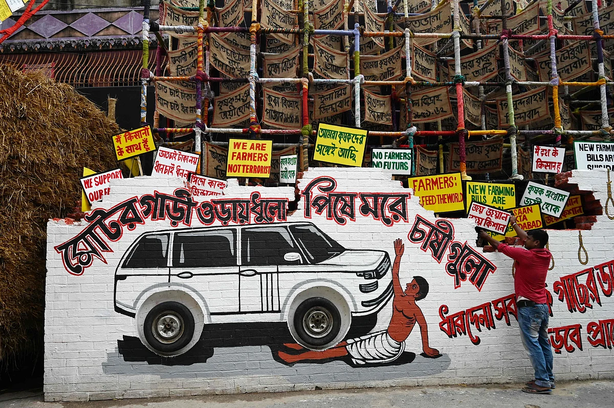 A worker decorates of a makeshift place of worship for Durga Puja with a theme in support the ongoing farmers protest against the central governments agricultural reforms, in Kolkata on October 6, 2021.