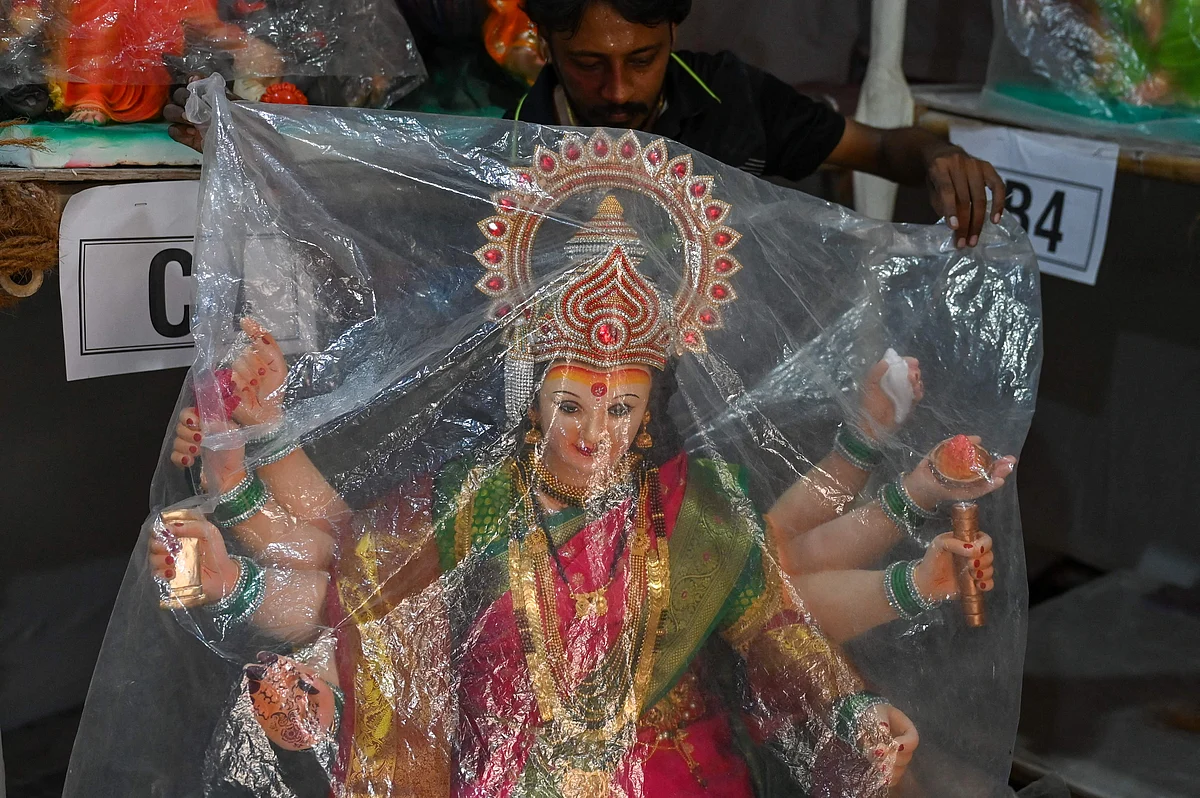 An artisan covers an idol of the Hindu goddess Durga with a plastic sheet at a workshop ahead of the upcoming Navratri festival, in Mumbai on October 5, 2021.
