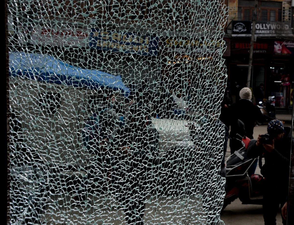 Press photographer takes a Picture on broken window of a shop after a grenade attack by suspected militants in Srinagar. P