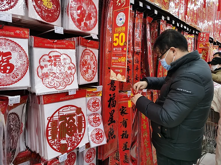 Customer chooses from an array of Spring Festival couplets to prepare for the Chinese New Year