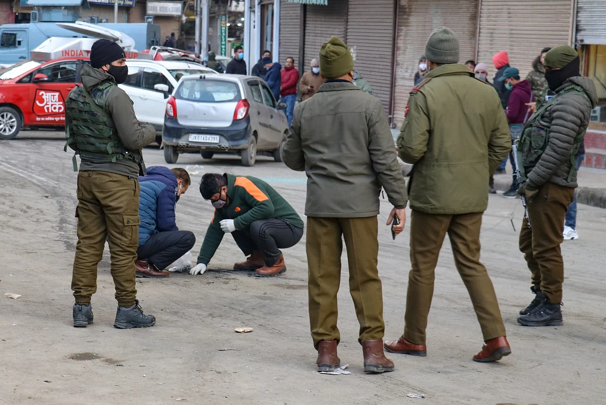 Police officers examine the scene after a grenade attack by suspected militants in Srinagar.