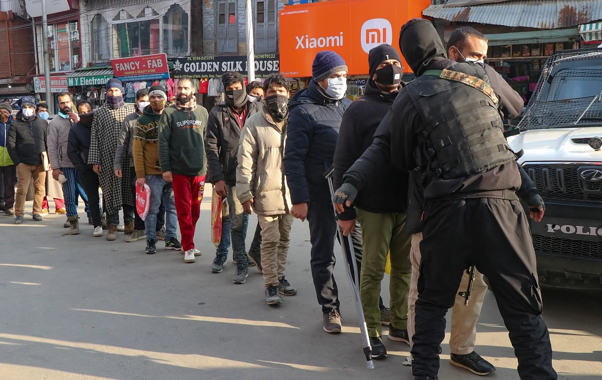 Policemen frisk a Kashmiri man as other wait for their turn after a grenade attack by suspected militants in Srinagar.