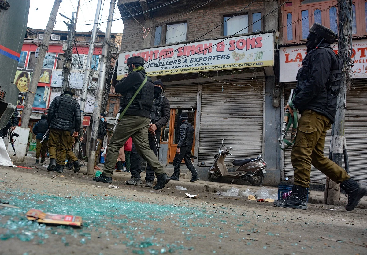 Paramilitary soldiers stand a near broken window of a shop after a grenade attack by suspected militants in Srinagar