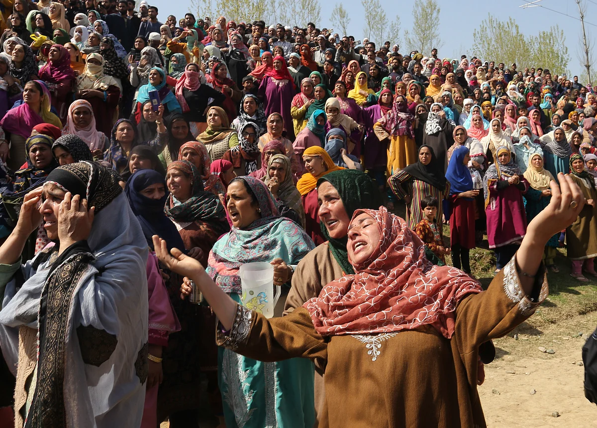 Kashmiri Villagers and relatives mourn at the funeral of slain policeman and his brother
