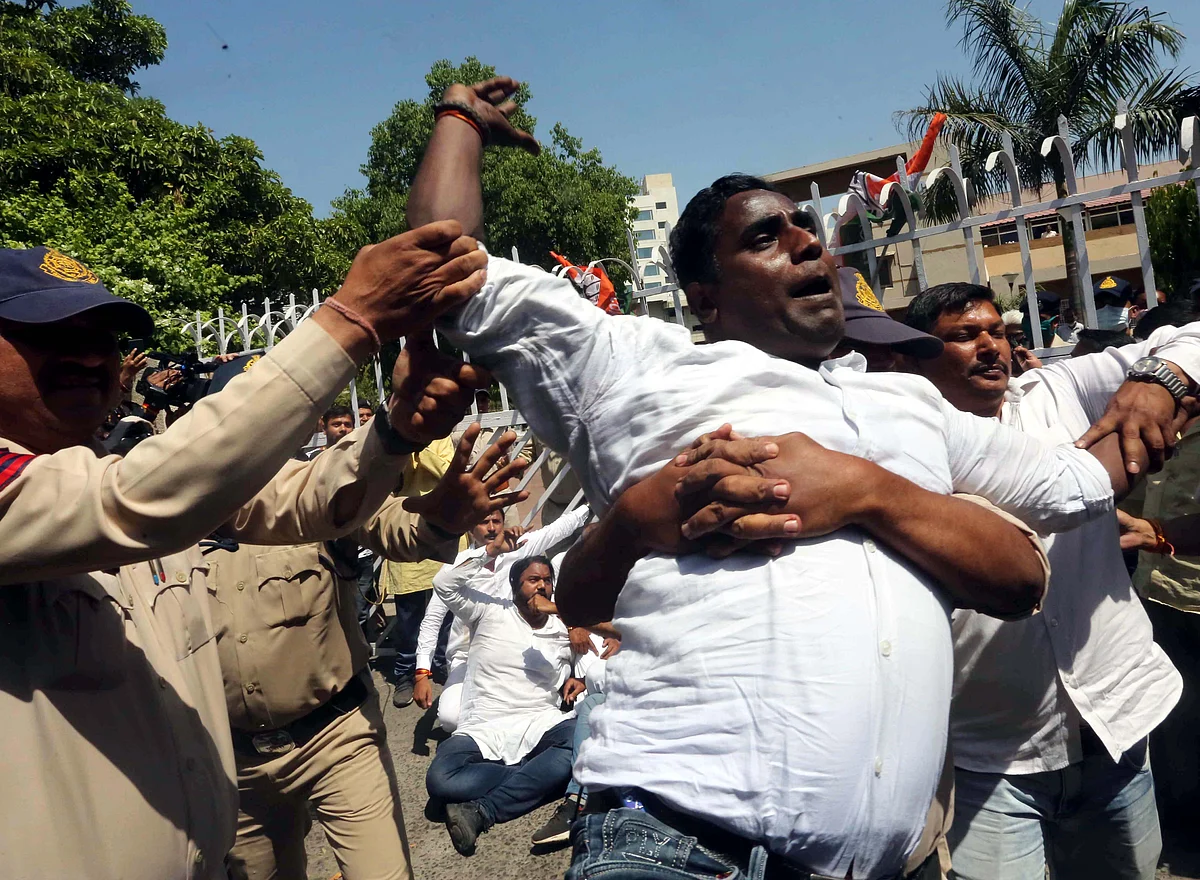 Police personnel detain Madhya Pradesh Youth Congress workers during their protest over alleged corruption in the Teacher Eligibility Test (TET) conducted by Vyapam, in front of the office of the Professional Examination Board, in Bhopal, Thursday,