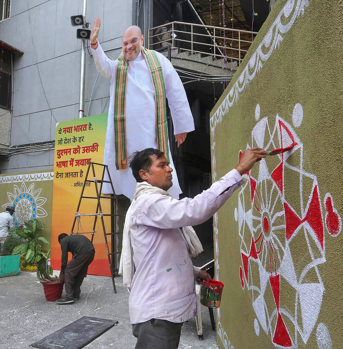 Workers paint murals in preparation for Union Home Minister Amit Shah's visit, at BJP state headquarters, in Bhopal, Thursday.
