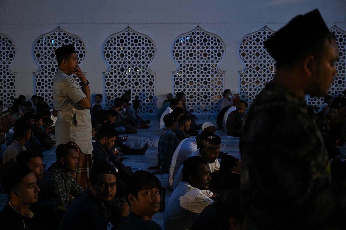 Muslim worshippers perform the first evening Tarawih prayer on the first night of the holy fasting month of Ramadan, at the Baiturrahman grand mosque in Banda Aceh on April 2, 2022. (Photo by CHAIDEER MAHYUDDIN / AFP)