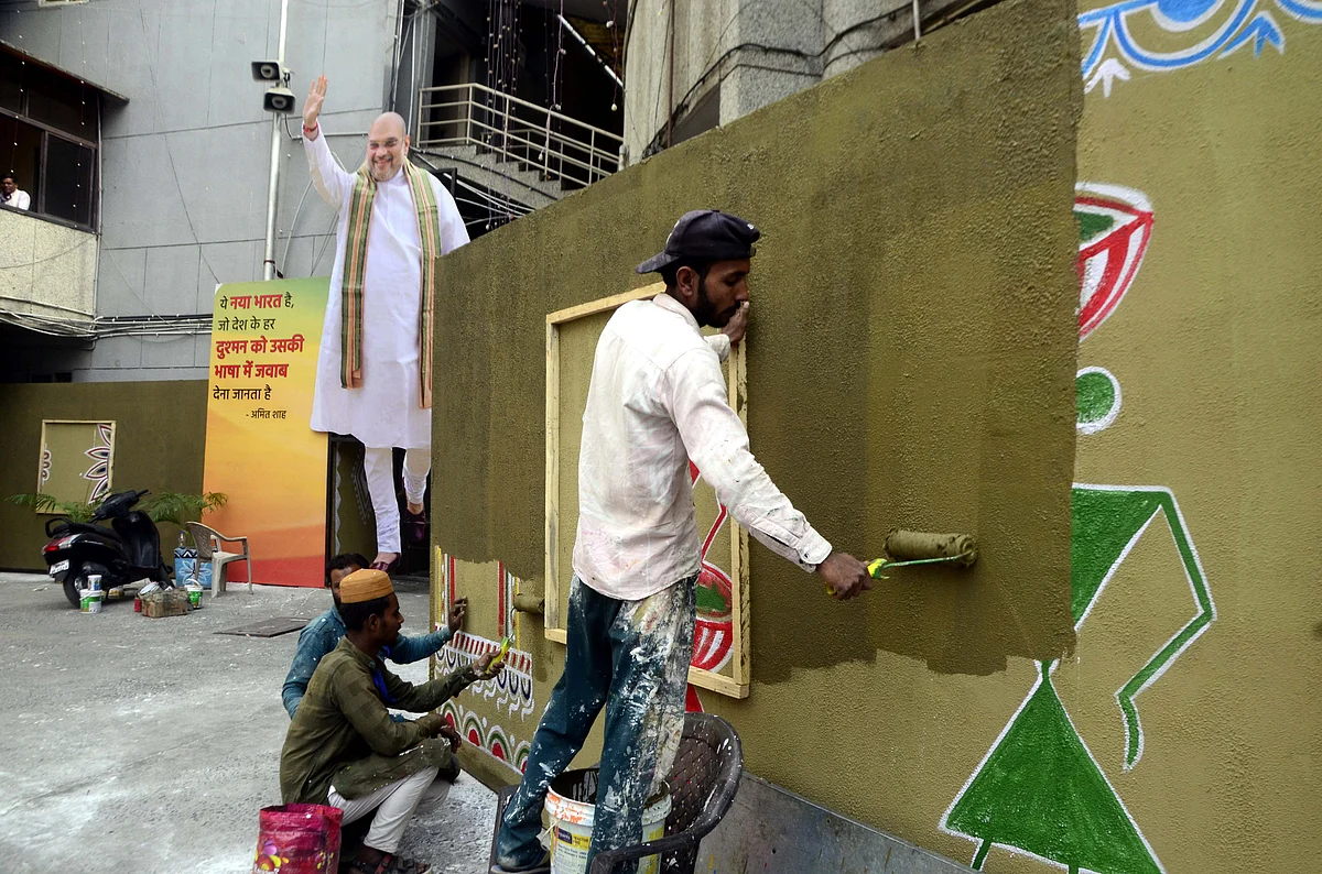 Workers paint murals in preparation for Union Home Minister Amit Shah's visit, at BJP state headquarters, in Bhopal, Thursday.