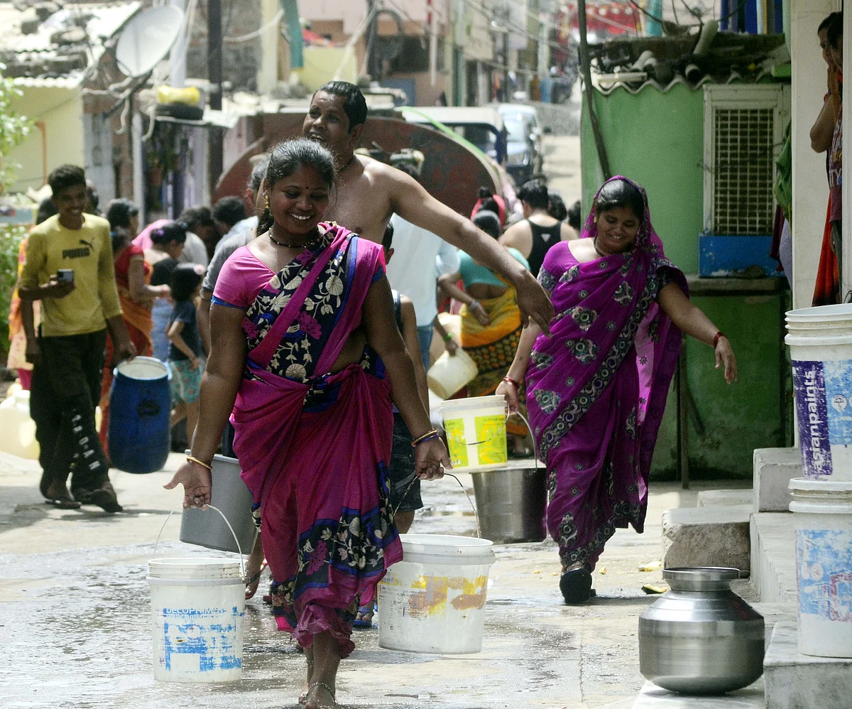 People in all smiles after getting water from a tanker in Kolar area in Bhopal on Sunday