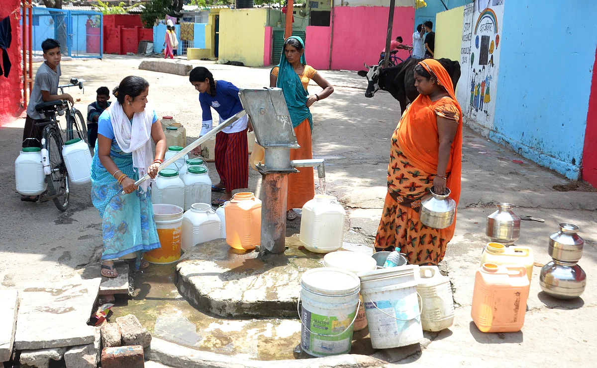 People drawing water from hand pump after pipe water supply remained disrupted for the fourth consecutive day on Sunday due to laying of new Kolar pipeline.