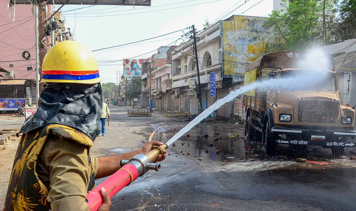 Prayagraj: A firefighter tries to douse a fire that was allegedly set ablaze by miscreants during a protest over controversial remarks made by two now-suspended BJP leaders about Prophet Mohammad, at Atala area in Prayagraj, Friday, June 10, 2022.