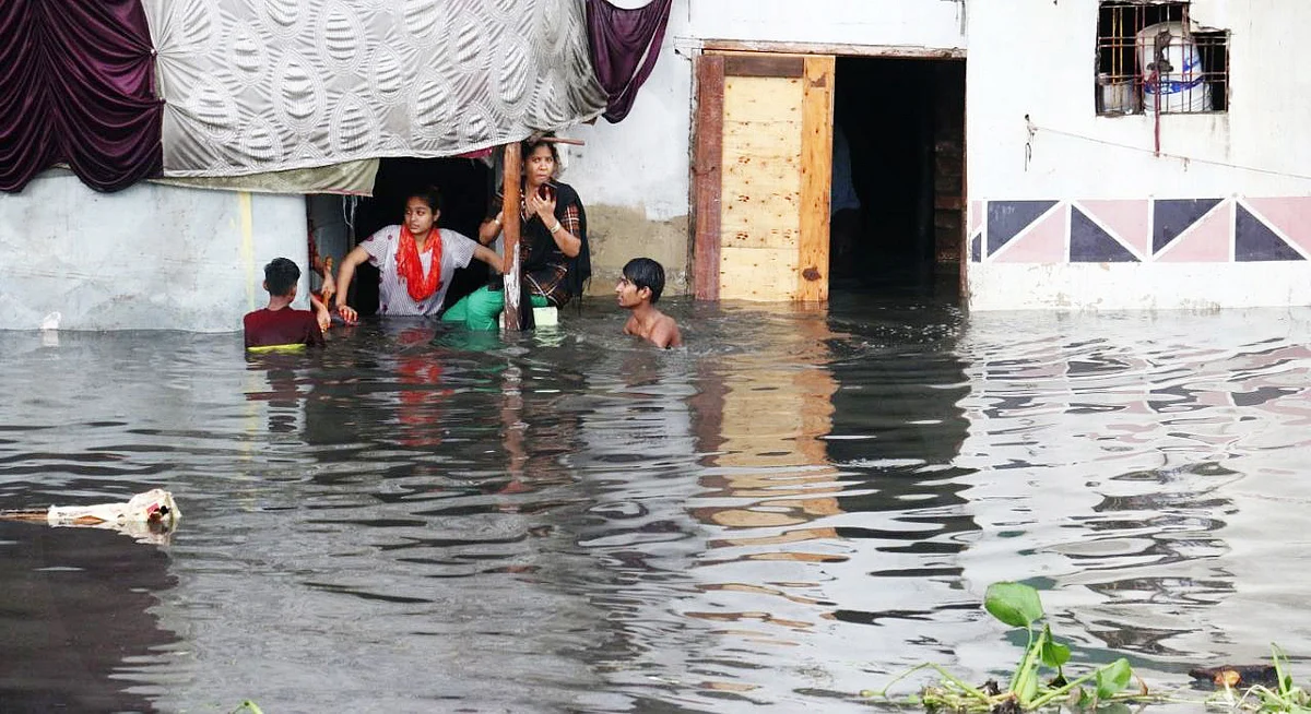 Waterlogging in a low-lying area. People try to drain out rainwater from their houses.