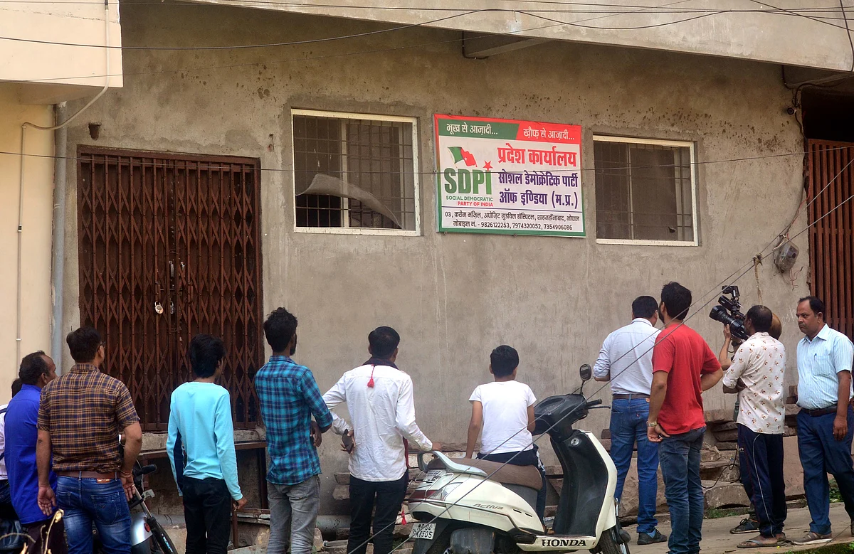 People gather near Social Democratic Party of India office in Shahjahanabad following raid in Bhopal on Tuesday