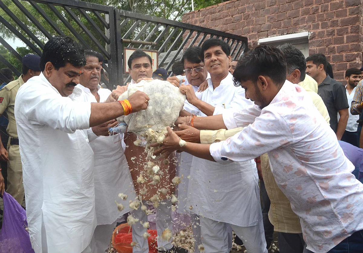 Congress MLAs stage a protest by dumping garlic at the gate of Madhya Pradesh Assembly on the first day of Monsoon Session, in Bhopal, Tuesday