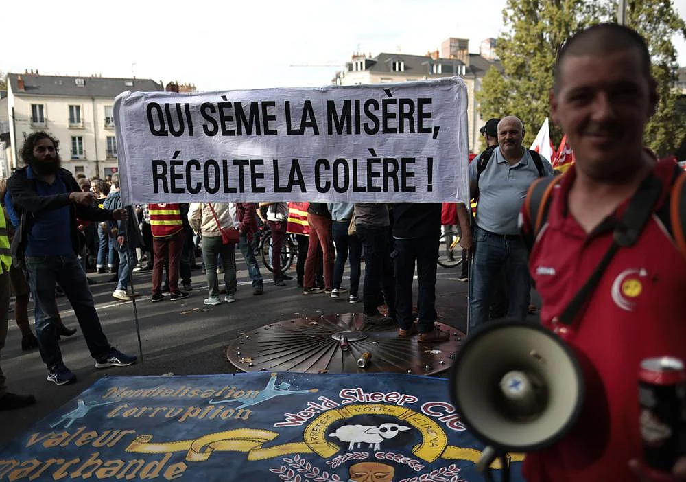 Protesters hold a banner that reads,