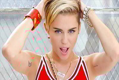 Miley Cyrus bites on a Barbie doll