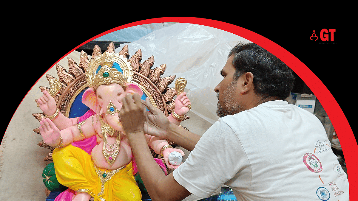An artisan gives the finishing touches to an idol of Lord Ganesha.