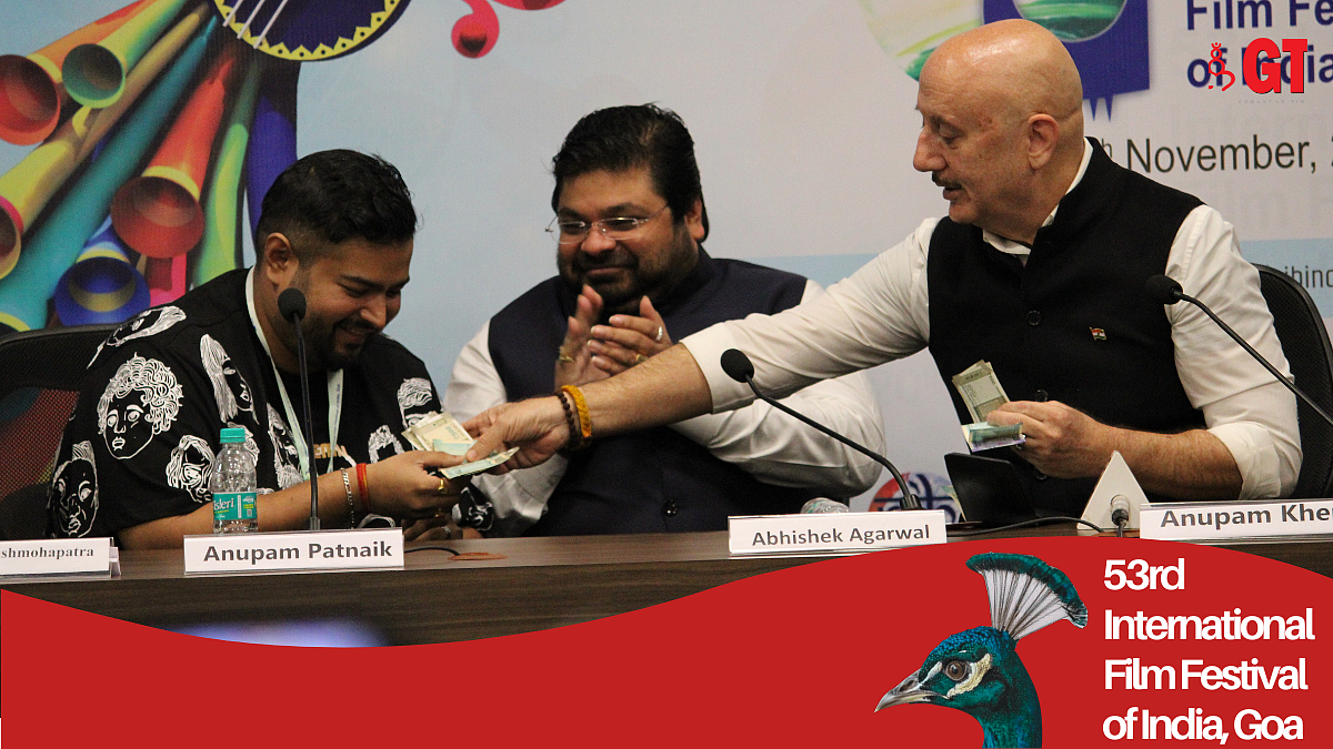 Anupam Kher giving Anupam Patnaik token money as a gesture.
